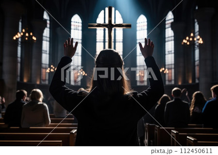 Capturing divine moments: church worship concept Christians, raised hands, earnestly pray and worship to cross in the sacred ambiance of a church building, expressing faith and spiritual connection. 112450611