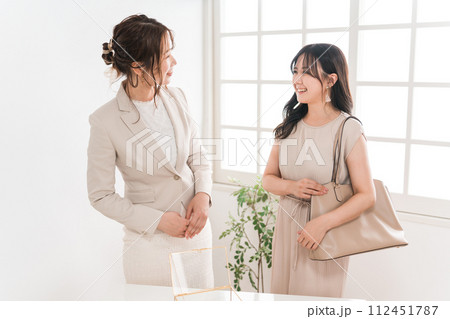 宝石店・アクセサリー・ジュエリーショップ・百貨店で買い物をする女性と販売員・スタッフ・コンシェルジュ 112451787