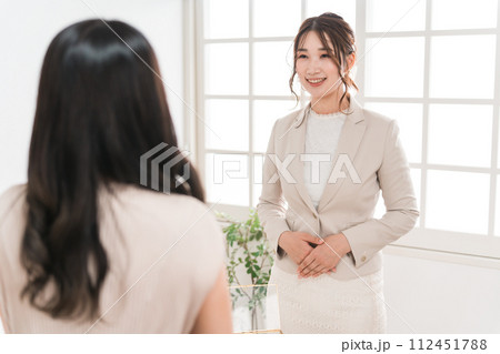 宝石店・アクセサリー・ジュエリーショップ・百貨店で買い物をする女性と販売員・スタッフ・コンシェルジュ 112451788