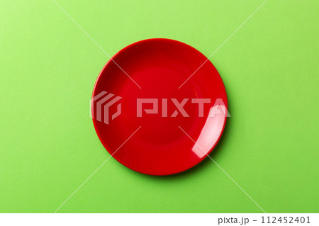 Top view of isolated of colored background empty round red plate for food. Empty dish with space for your design 112452401