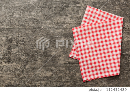 top view with red empty kitchen napkin isolated on table background. Folded cloth for mockup with copy space, Flat lay. Minimal style 112452429