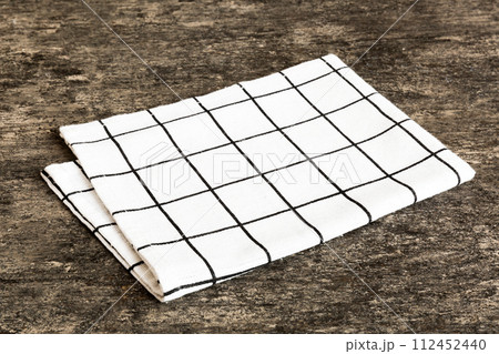 top view with white empty kitchen napkin isolated on table background. Folded cloth for mockup with copy space, Flat lay. Minimal style 112452440