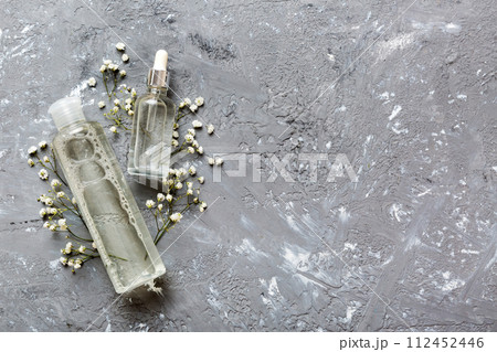 Fancy healthcare bottles for serum, micellar, tonic, toner, lotion, water and cream with gypsophila branch. Natural oranic spa cosmetics concept. Mockup, template, Top view Fancy healthcare bottles for serum, micellar, tonic, toner, lotion, water and cream with gypsophila branch. Natural oranic spa cosmetics concept. Mockup, template, Top view 112452446