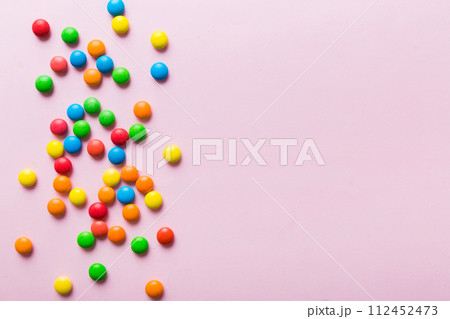 Mixed collection of colorful candy, on colored background. Flat lay, top view. frame of colorful chocolate coated candy 112452473