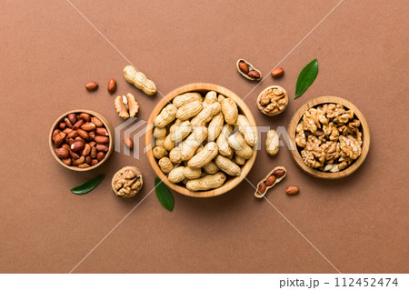 Walnut kernel halves, in a wooden bowl. Close-up, from above on colored background. Healthy eating Walnut concept. Super foods with copy space Walnut kernel halves, in a wooden bowl. Close-up, from above on colored background. Healthy eating Walnut concept. Super foods with copy space 112452474