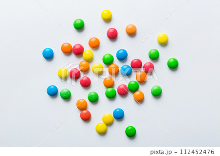 Mixed collection of colorful candy, on colored background. Flat lay, top view. frame of colorful chocolate coated candy Mixed collection of colorful candy, on colored background. Flat lay, top view. frame of colorful chocolate coated candy 112452476