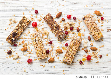 Various granola bars on table background. Cereal granola bars. Superfood breakfast bars with oats, nuts and berries, close up. Superfood concept Various granola bars on table background. Cereal granola bars. Superfood breakfast bars with oats, nuts and berries, close up. Superfood concept 112452733