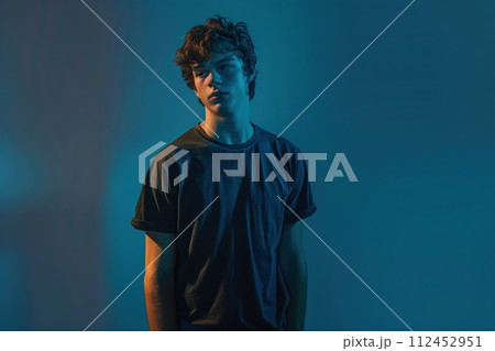A man in a black shirt stands in front of a blue wall 112452951