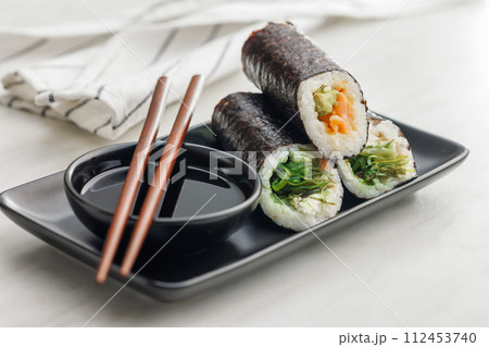 Sushi rolls on Plate with bowl of soy sauce and chopsticks. Sushi rolls on Plate with bowl of soy sauce and chopsticks. 112453740