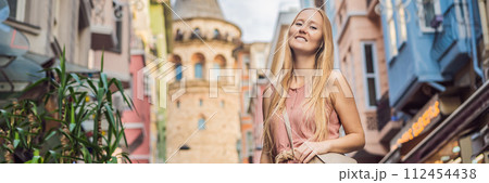 Portrait of beautiful woman tourist with view of Galata tower in Beyoglu, Istanbul, Turkey. Turkiye BANNER, LONG FORMAT Portrait of beautiful woman tourist with view of Galata tower in Beyoglu, Istanbul, Turkey. Turkiye BANNER, LONG FORMAT 112454438