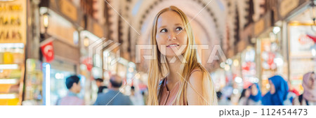 BANNER, LONG FORMAT A tourist woman walks among the countless shops at the Grand Bazaar and Egyptian Bazaar in Istanbul. Shopping and travel in Turkey concept. Istanbul historical Egyptian Bazaar 112454473