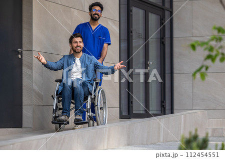 Patient and a male nurse on a walk in a hospital yard Patient and a male nurse on a walk in a hospital yard 112454551