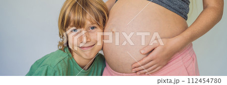 BANNER, LONG FORMAT Young beautiful pregnant woman and eldest son. The cute boy leaned his ear against his mother's belly. Expecting a baby in the family concept. Preparing an older child for a BANNER, LONG FORMAT Young beautiful pregnant woman and eldest son. The cute boy leaned his ear against his mother's belly. Expecting a baby in the family concept. Preparing an older child for a 112454780