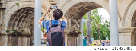 BANNER, LONG FORMAT Happy male tourist traveler discover interesting places and popular attractions and walks in the old city of Antalya. Hadrian Kapisi turkey landmark city history. Popular tourist 112455490