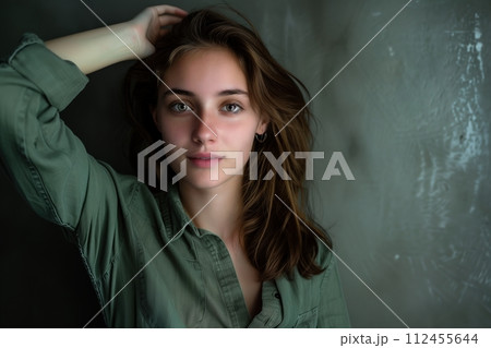 A woman with long brown hair is wearing a green shirt 112455644