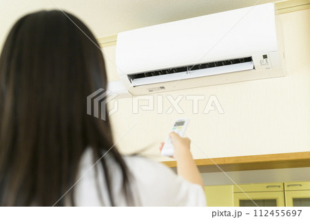 エアコンを操作する女性（エアコン本体にピント） 112455697