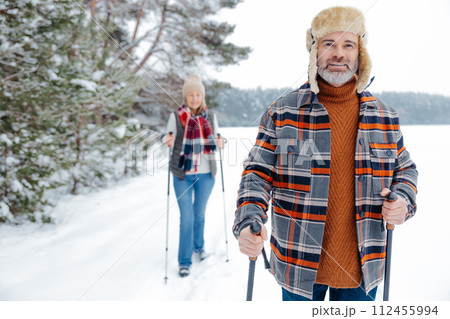 Couple on a walk with scandinavian sticks 112455994