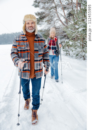 Couple on a walk with scandinavian sticks 112455995