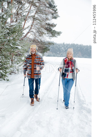 Couple on a walk with scandinavian sticks 112455996