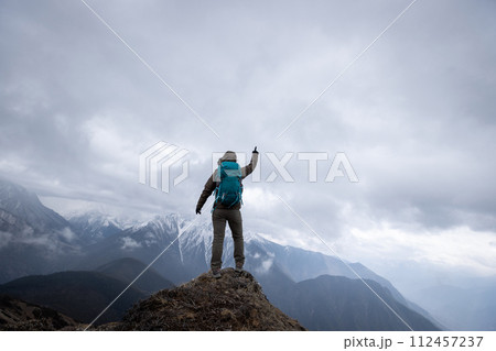 Woman hiker hiking at mountain top in tibet Woman hiker hiking at mountain top in tibet 112457237