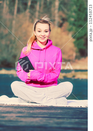 Girl learning yoga from tablet. 112458713
