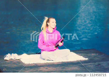 Girl learning yoga from tablet. 112458715
