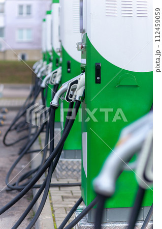 Car parking with charging stations near a multi-storey apartment building. 112459059