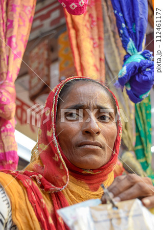 Indian Woman with beautiful face posing with textiles in background Indian Woman with beautiful face posing with textiles in background 112461177