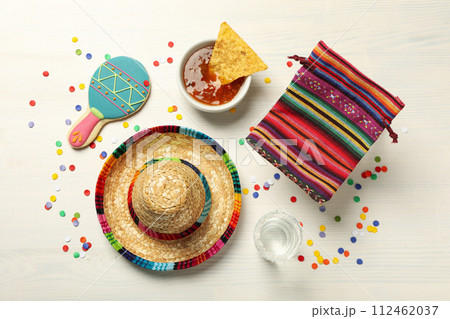 Nachos with sombrero and tequila on a light background Nachos with sombrero and tequila on a light background 112462037