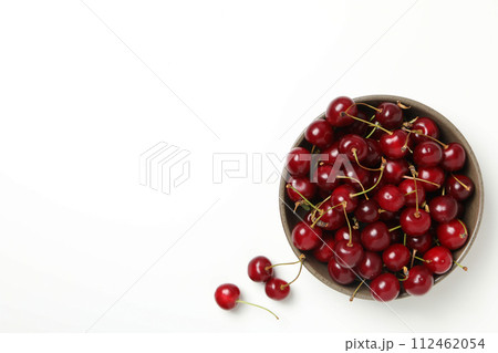Ripe cherry fruits in a bowl on a white background 112462054