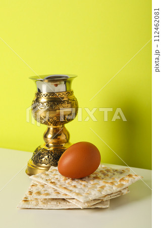 Matzo, egg and cup on yellow background 112462081
