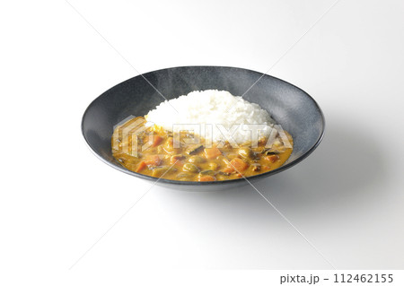 豚肉、かぼちゃ、人参などの野菜が沢山入った熱々カレーライスを白背景で撮影 112462155