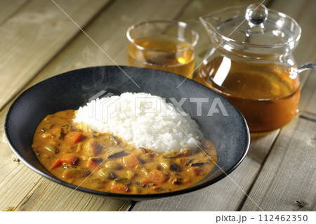 豚肉、かぼちゃ、人参などの野菜が沢山入った熱々カレーライスとお茶 112462350