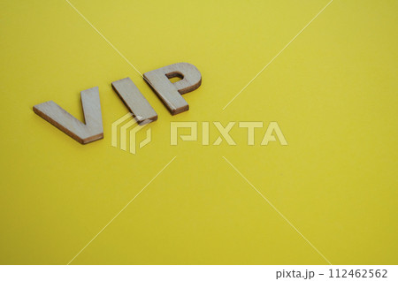 VIP wooden letters representing Very Important People on yellow background 112462562