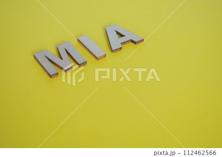 MIA wooden letters representing Missing In Action on yellow background MIA wooden letters representing Missing In Action on yellow background 112462566