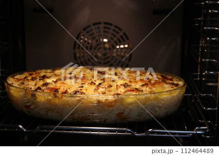 A mixture of fried vegetables is baked in the oven in a transparent dish. A mixture of fried vegetables is baked in the oven in a transparent dish. 112464489