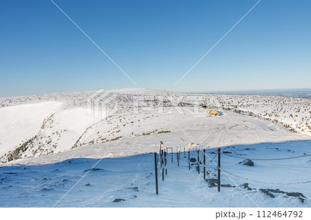 Winter morning , steel railing tube with a chain on path from Snezka to Silesian house, krkonose mountains. Snezka is mountain on the border between Czech Republic and Poland. Winter morning , steel railing tube with a chain on path from Snezka to Silesian house, krkonose mountains. Snezka is mountain on the border between Czech Republic and Poland. 112464792