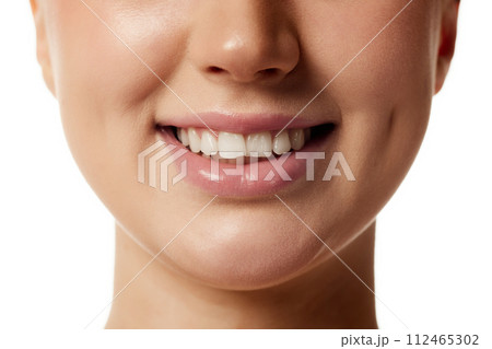 Close up photo of young attractive woman smiling with wide and healthy smile against white studio background. Close up photo of young attractive woman smiling with wide and healthy smile against white studio background. 112465302
