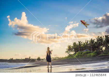 A young woman launches a kite on the beach. Dream, aspirations, future plans A young woman launches a kite on the beach. Dream, aspirations, future plans 112465644