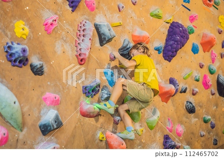 little boy climbing a rock wall in special boots. indoor 112465702