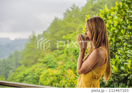 Young woman drinks coffee in a cafe in the mountains Young woman drinks coffee in a cafe in the mountains 112467103