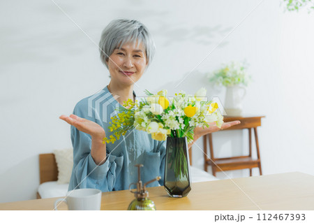 花を花瓶に飾るシニア女性 花を花瓶に飾るシニア女性 112467393