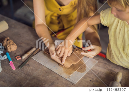 mother and son doing ceramic pot in pottery workshop 112468397