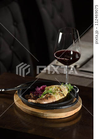 Chicken leg stuffed, served with vegetables on a black plate Chicken leg stuffed, served with vegetables on a black plate 112469075