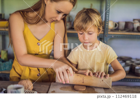 mother and son doing ceramic pot in pottery workshop mother and son doing ceramic pot in pottery workshop 112469118