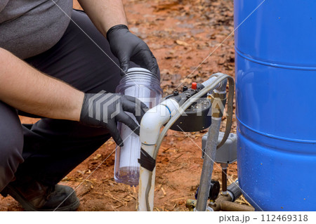 Installation of new water purification filter cartridge by maintenance serviceman Installation of new water purification filter cartridge by maintenance serviceman 112469318
