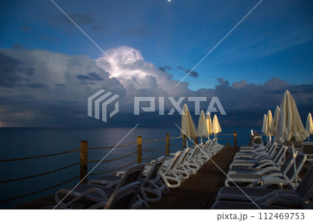 Thunderstorm with lightning in the sky over the pier in the early morning 112469753