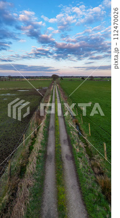 Country Road Embraced by Twilight Sky: Aerial Journey Through Farmland 112470026