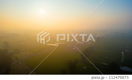 Misty Morning Glow Over Rural Landscape with Patches of Water Misty Morning Glow Over Rural Landscape with Patches of Water 112470073