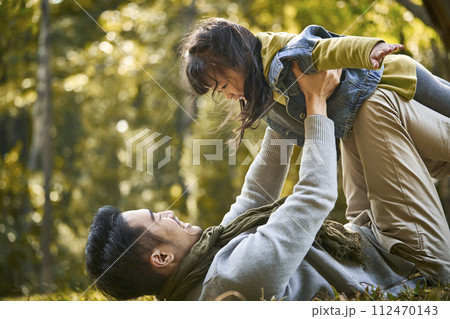 asian father and daughter having fun outdoors in park asian father and daughter having fun outdoors in park 112470143